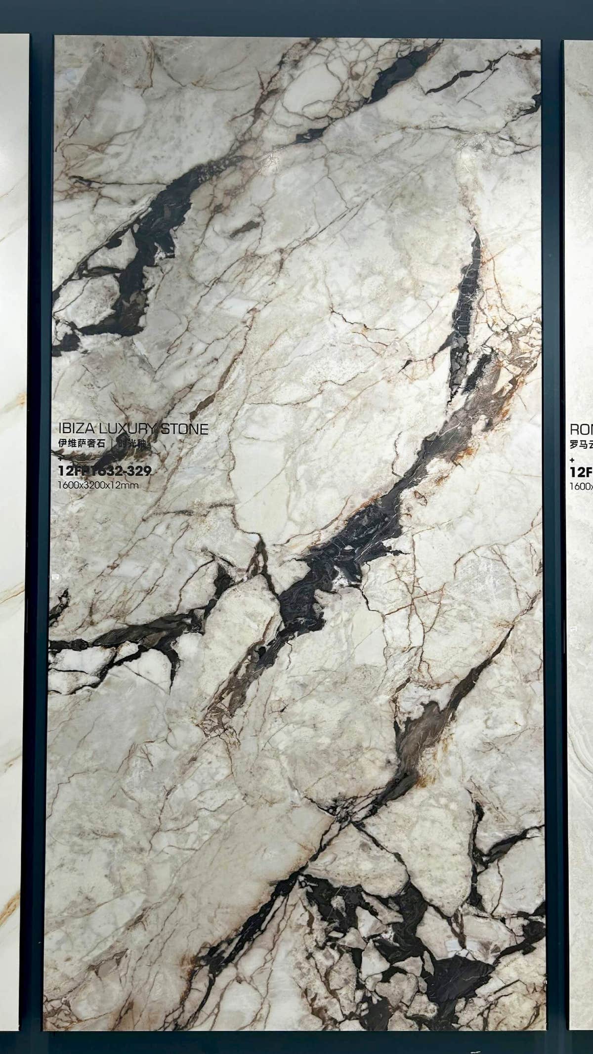 لوح أبيض تقسمه عروق رمادية وبنية بارزة داخل إطار عرض — حجر ملبّد Ibiza Luxury Stone White Breccia Look