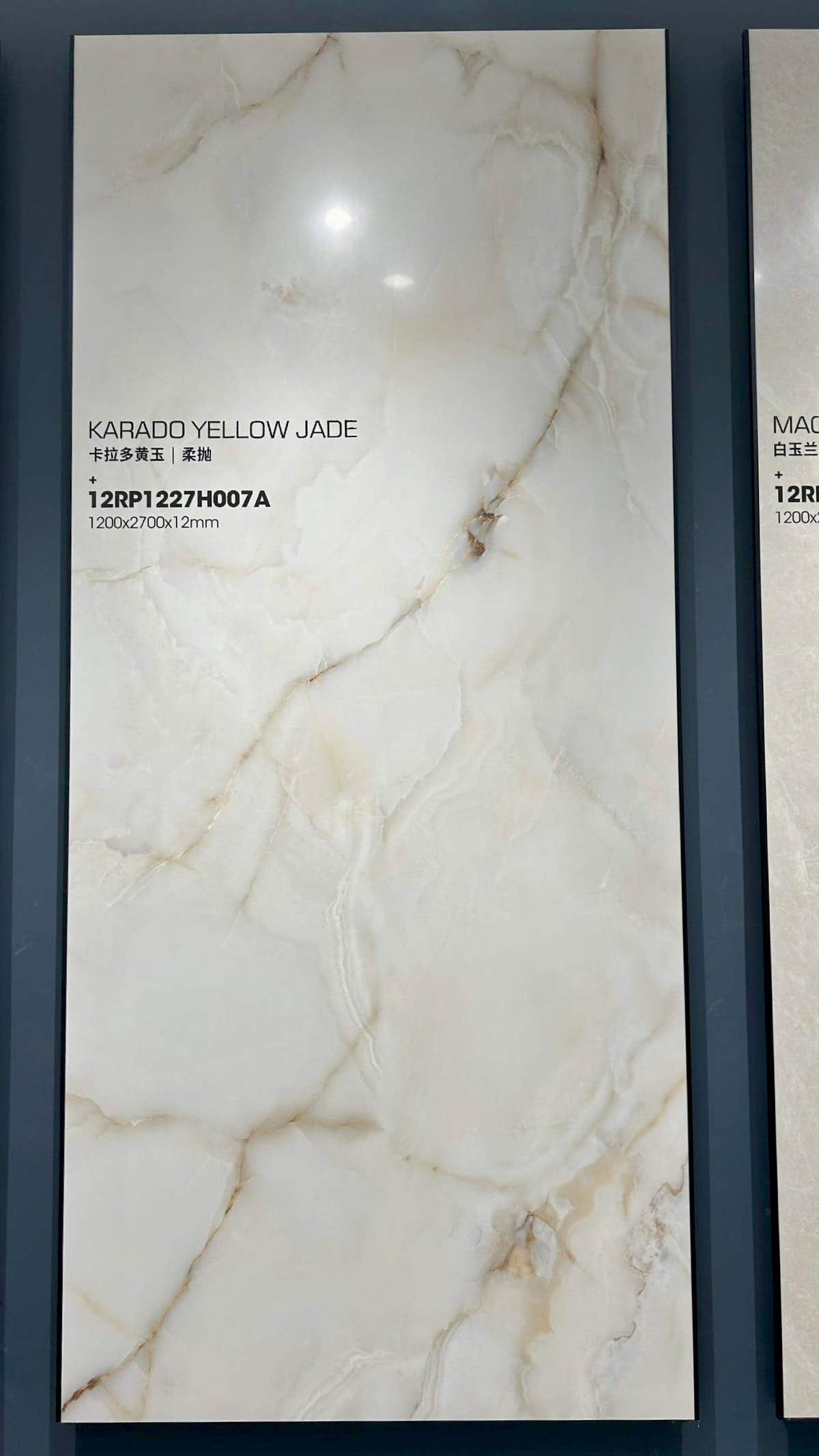Dalle crème à fines veines dorées et grises dans un cadre d’exposition — pierre frittée Karado Yellow Jade Ivory Onyx Look