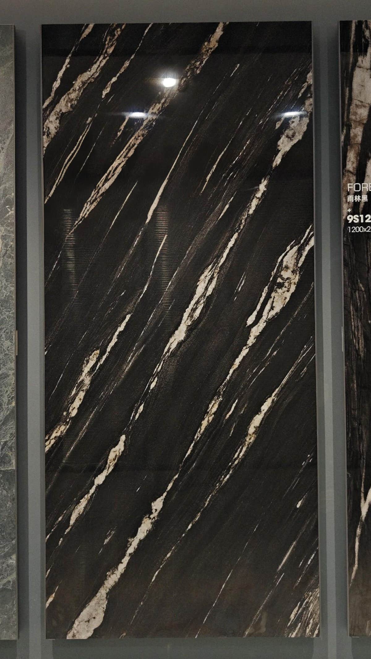 Black and gold-veined slab in a showroom display frame — Brazilian Black Gold sintered stone