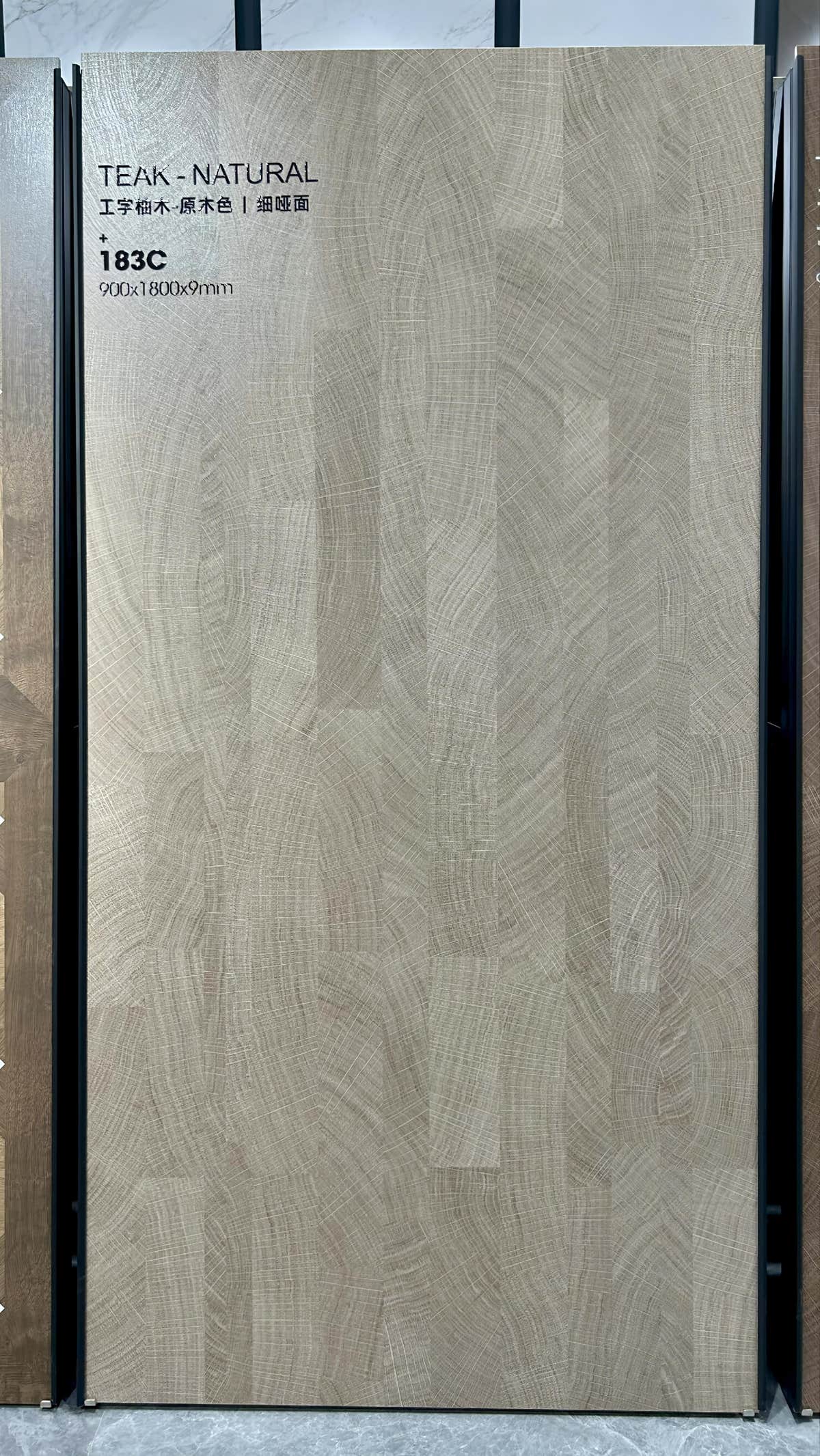 Dalle gris-brun à l’aspect bois sur un présentoir du showroom — pierre frittée Natural Teak Wood Look