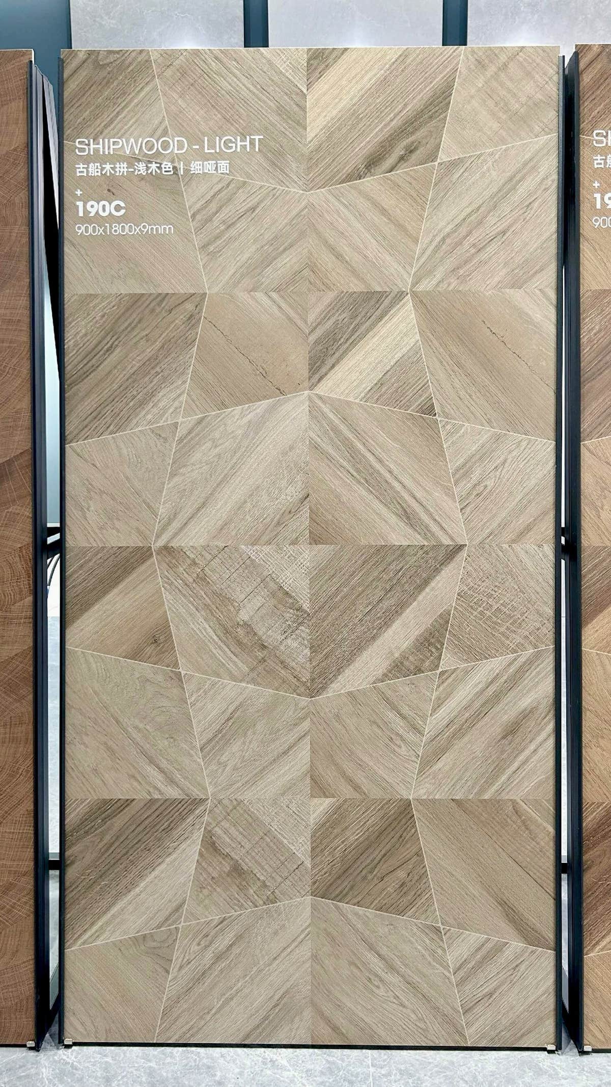 Panneau clair à motif géométrique et à l’aspect bois sur un présentoir du showroom — pierre frittée Light Shipwood Geometric Wood Look
