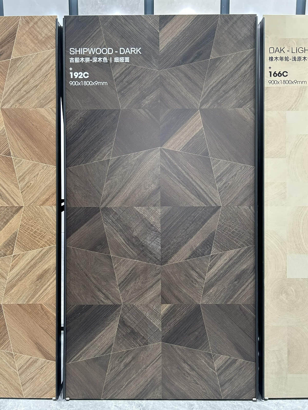 Panneau sombre à motif géométrique et à l’aspect bois sur un présentoir du showroom — pierre frittée Dark Shipwood Geometric Wood Look