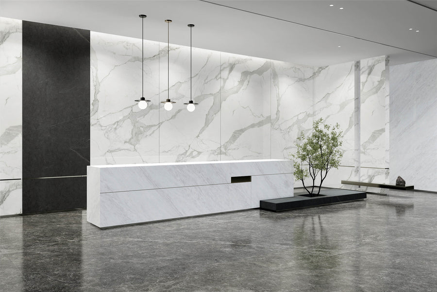 Luxury reception space with white marble-look sintered stone wall panels, reception desk, and polished dark floor