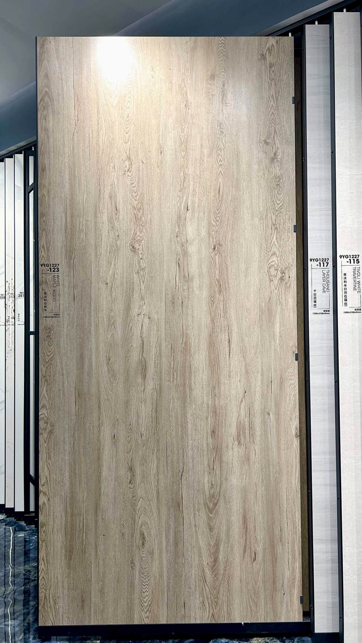 Dalle claire à l’aspect érable sur un présentoir du showroom — pierre frittée White Maple Wood Look