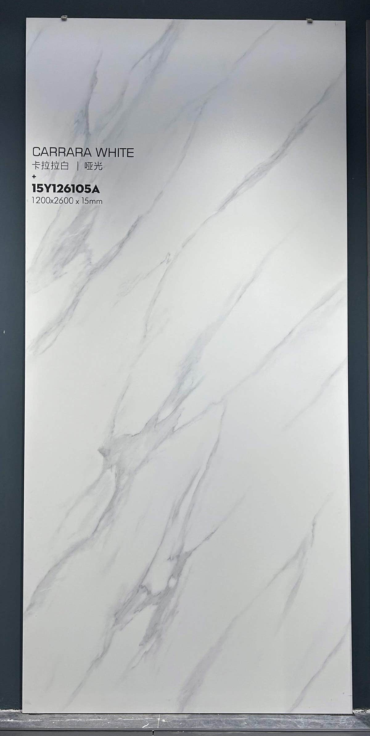 White and grey-veined slab in a showroom frame — Carrara White sintered stone