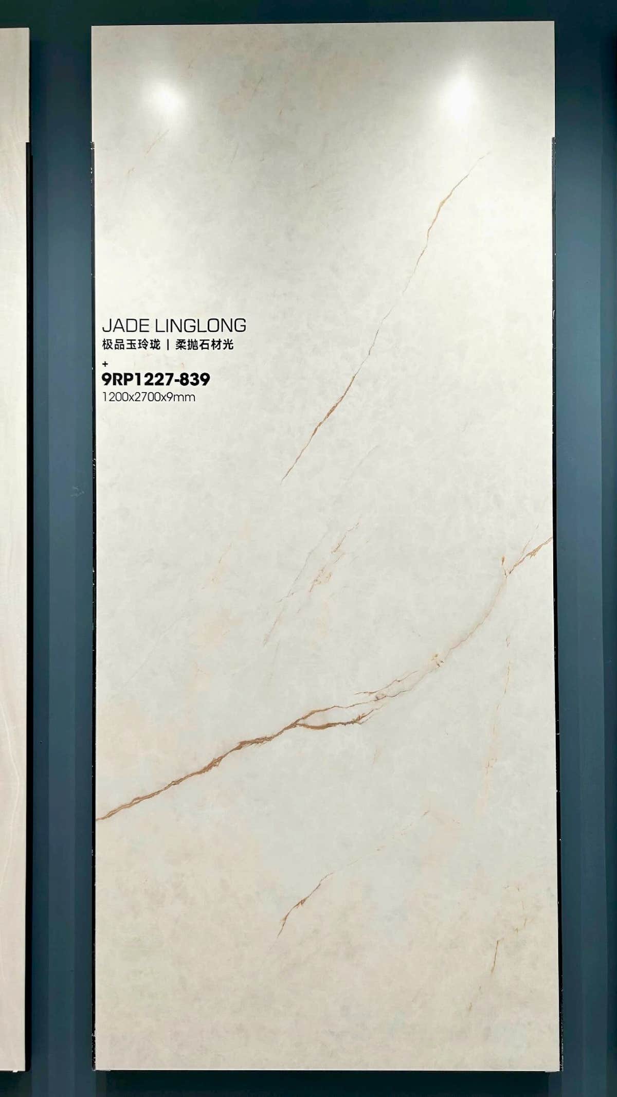 Placa crema pálido de piedra sinterizada con finas vetas doradas y grises en un marco expositor