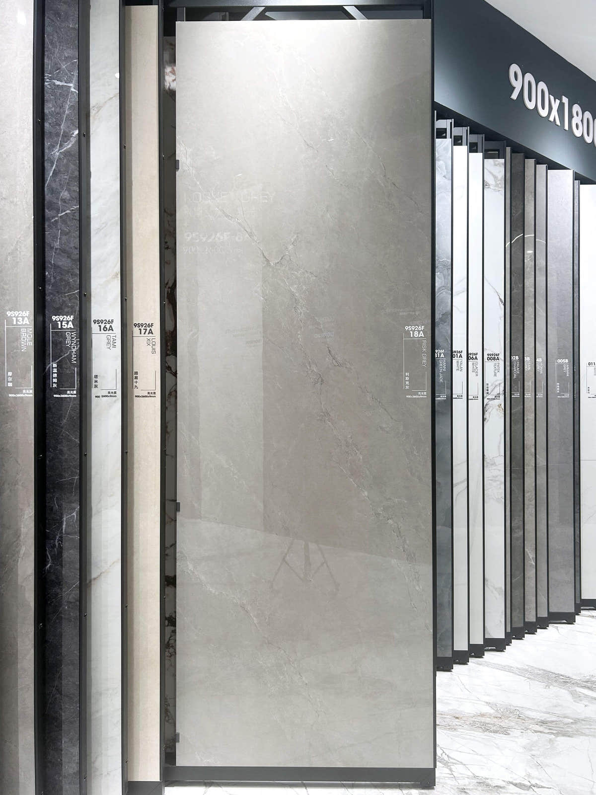 Grey stone-look slab on a swing-out showroom rack — Lisk Grey Look sintered stone