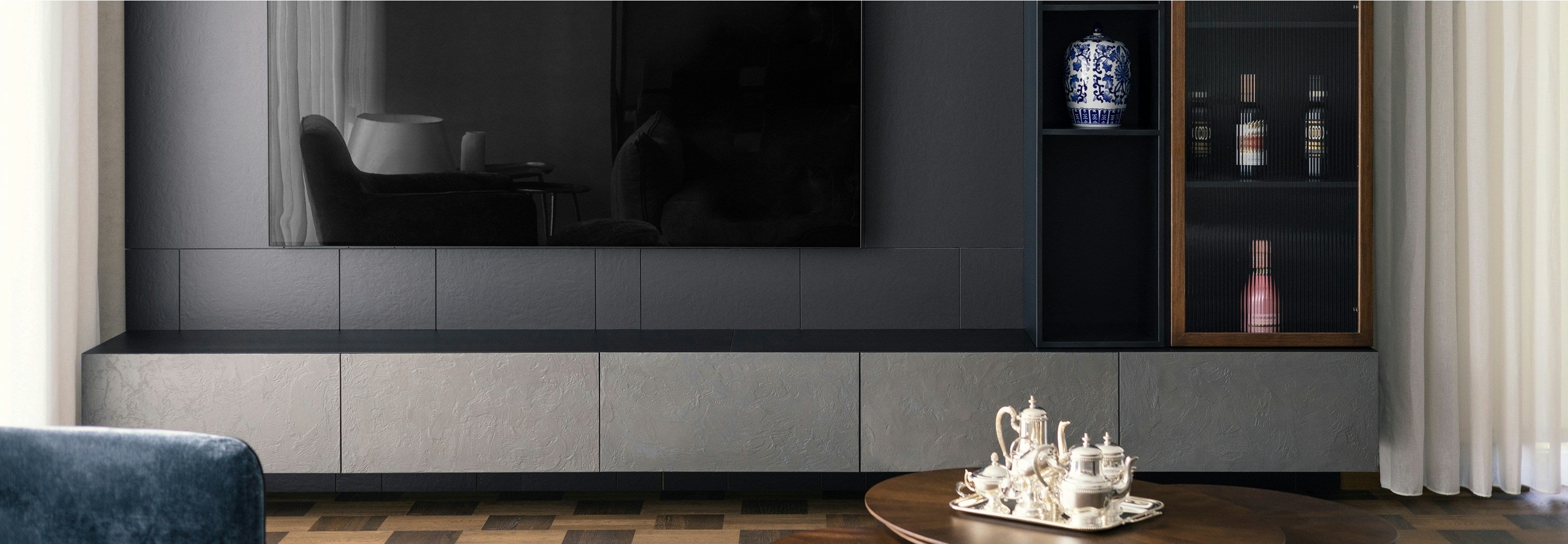 Dark contemporary living room with sintered stone furniture and cabinetry