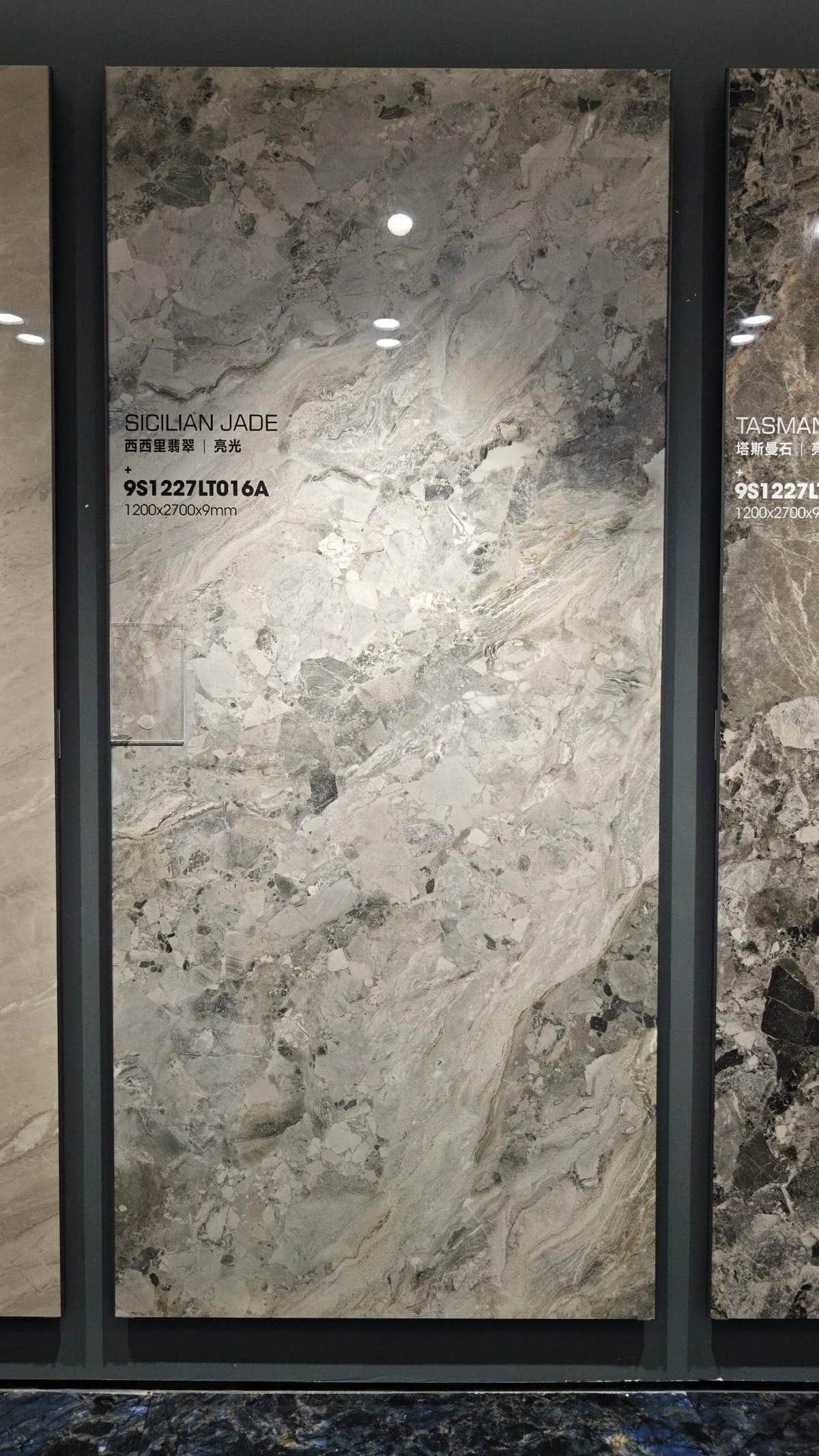 Dalle gris pâle à motif fragmenté dans un cadre de présentation du showroom — pierre frittée Sicilian Jade White Breccia Look