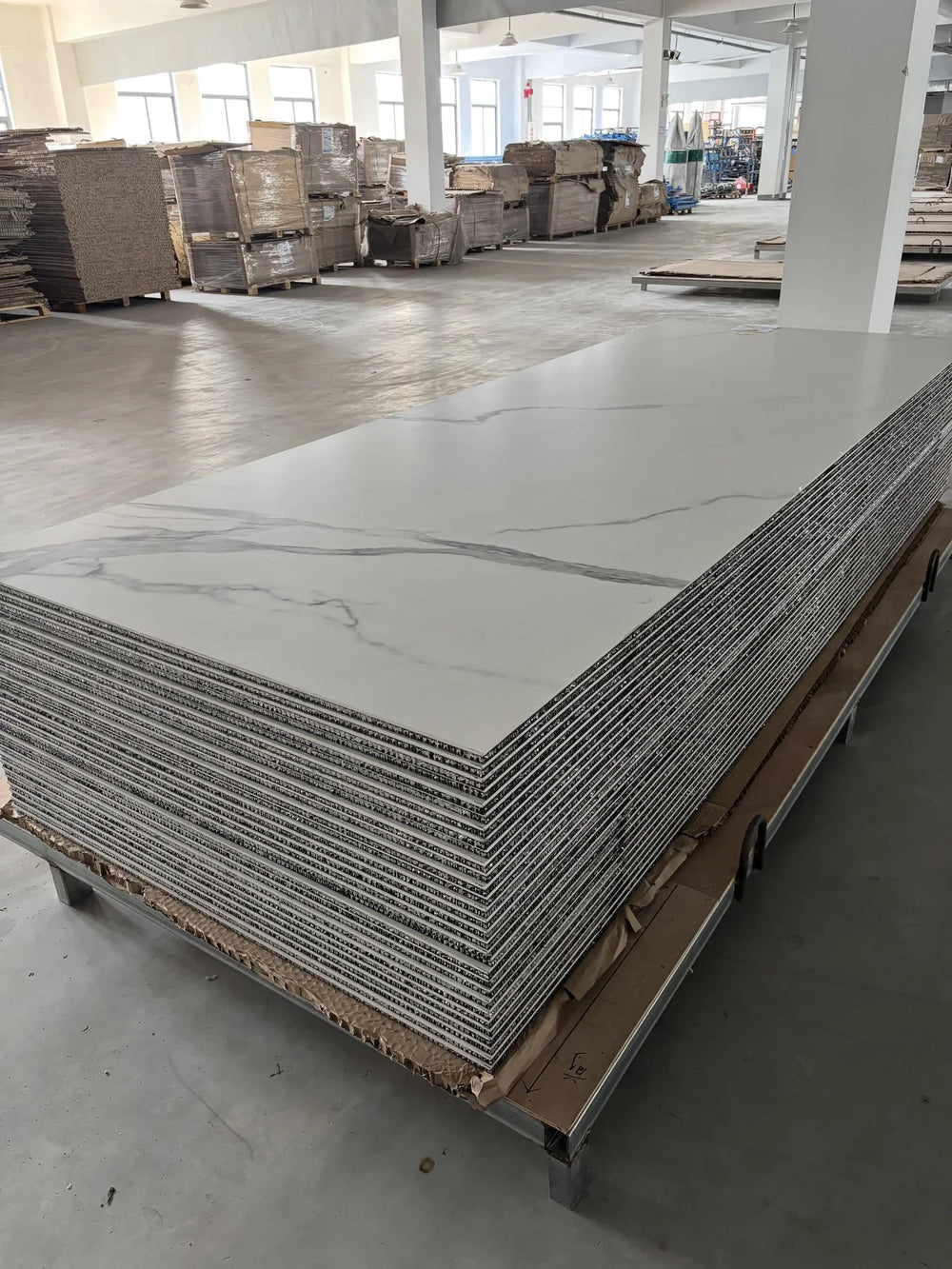 Finished large porcelain-faced honeycomb panels stacked with their thin composite edges visible