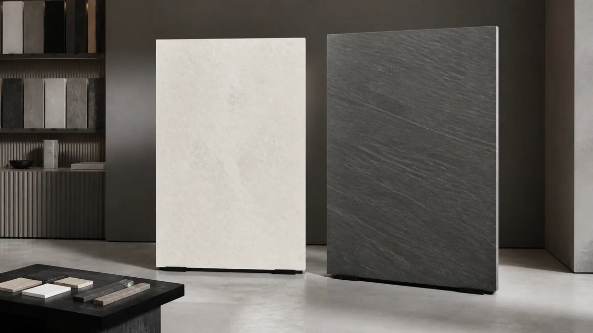 Two unlabeled large-format mineral surface slabs compared in an architectural materials studio