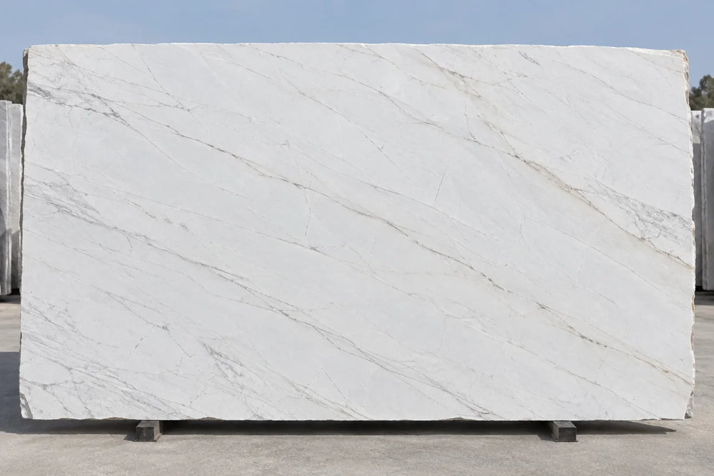 Large cream-white stone slab with fine diagonal gray and taupe veins on a stone-yard stand
