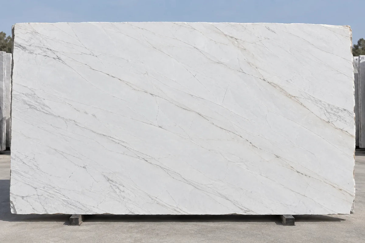 Large cream-white stone slab with fine diagonal gray and taupe veins on a stone-yard stand