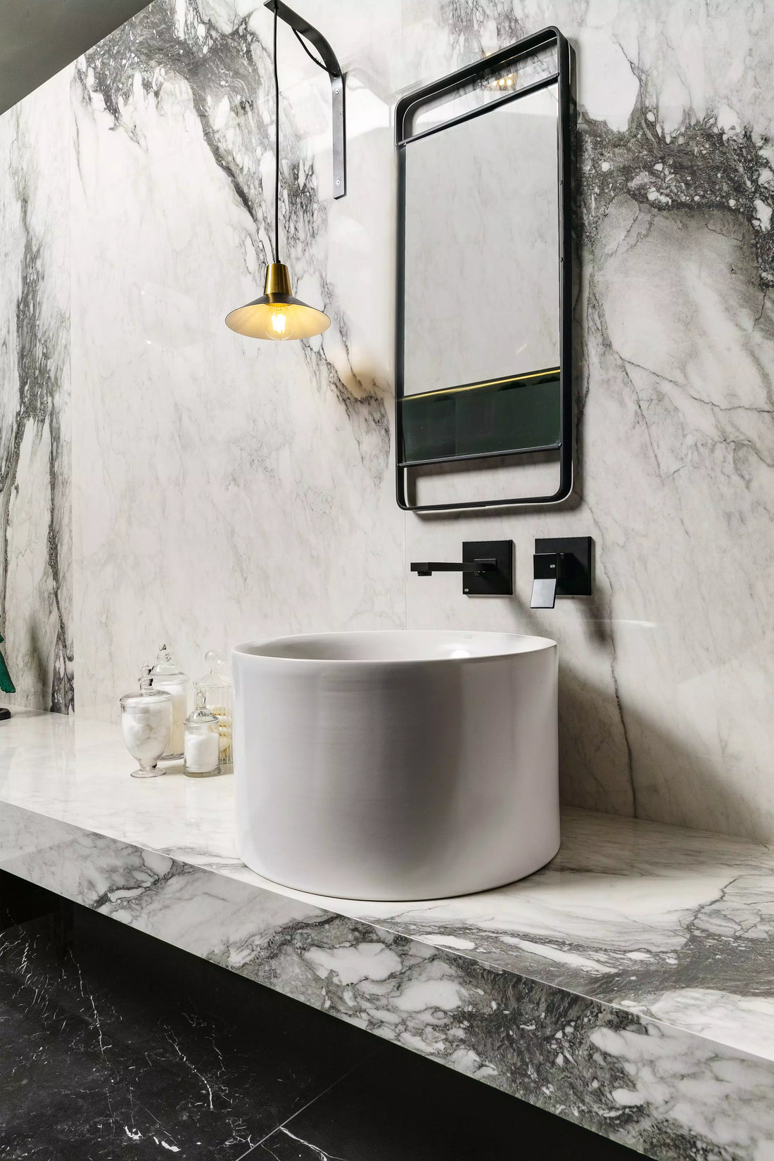 Vanité de salle de bain moderne avec lavabo rond en pierre frittée veinée de marbre blanc et miroir à cadre noir avec suspension en laiton