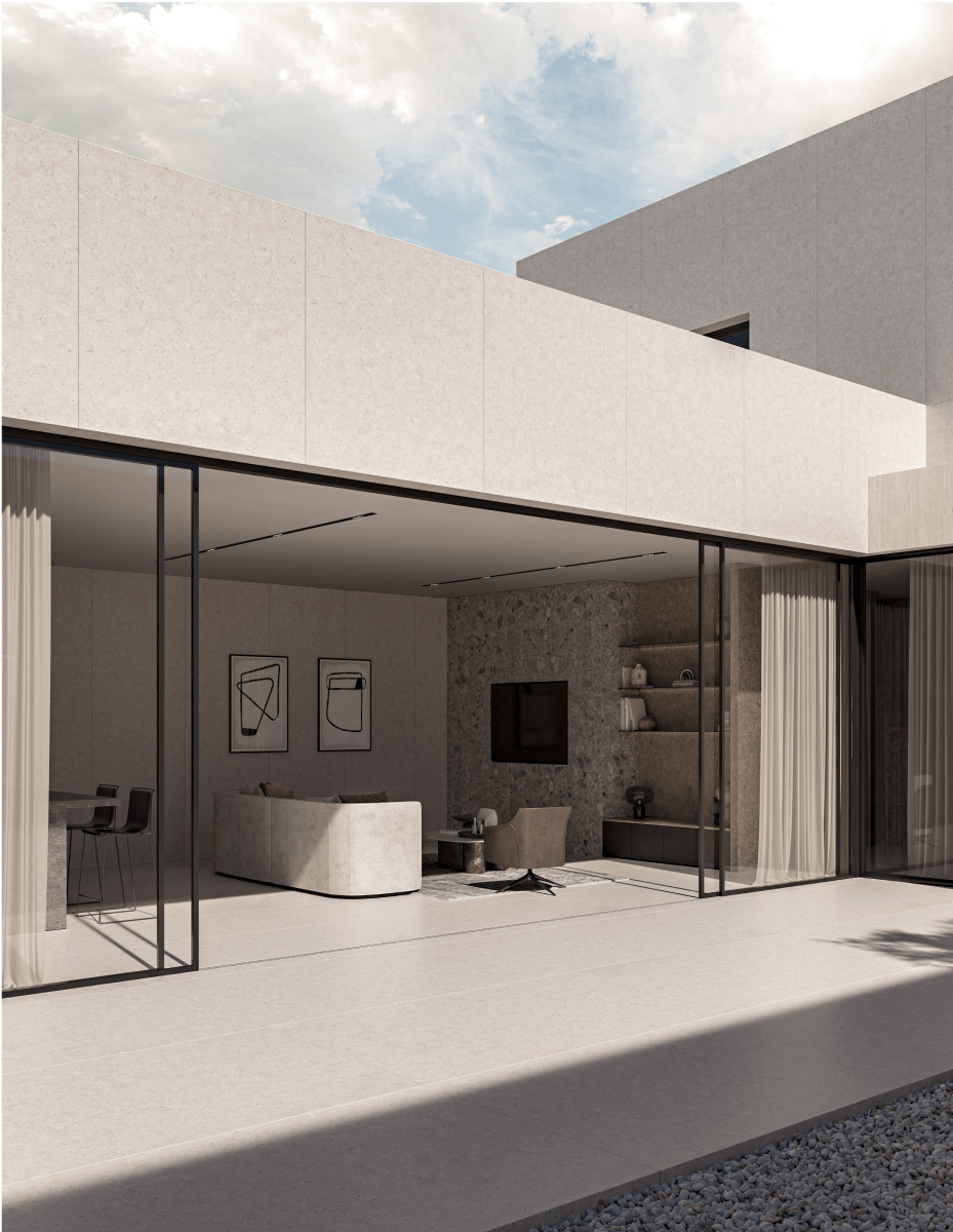 Modern minimalist interior with floor-to-ceiling glass sliding doors opening to outdoor patio, featuring white sintered stone walls and flooring, contemporary living room with white sofa, dining area with table and chairs, abstract wall art, and natural light flooding the open concept space