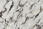 Panneaux côte à côte montrant des fragments blancs séparés par des veines gris foncé et rouille — pierre frittée Ibiza Luxury Stone White Breccia Look