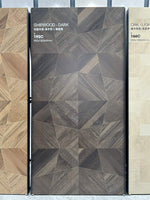 Panneau sombre à motif géométrique et à l’aspect bois sur un présentoir du showroom — pierre frittée Dark Shipwood Geometric Wood Look