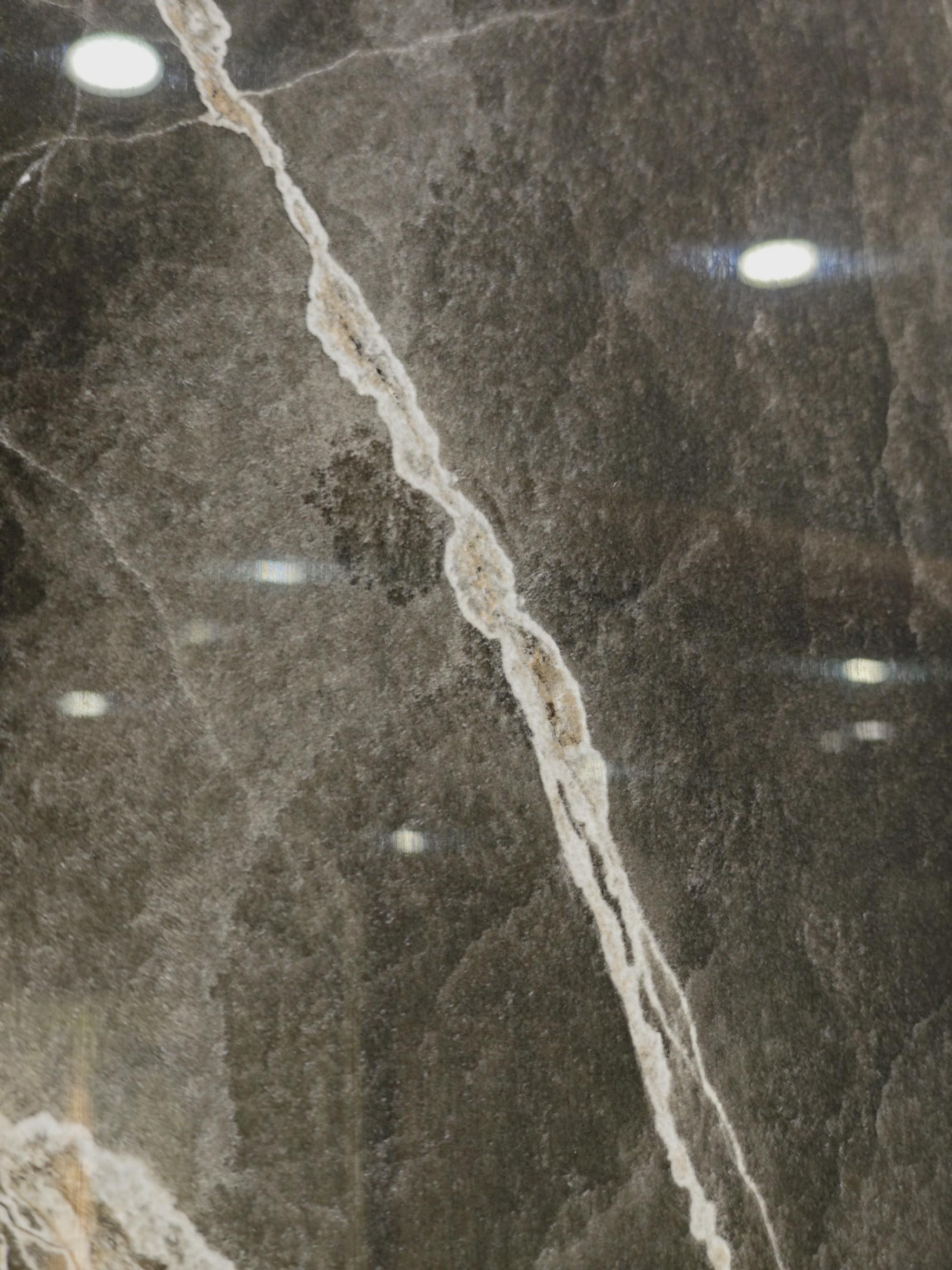 Close-up of polished charcoal stone with a white mineral vein