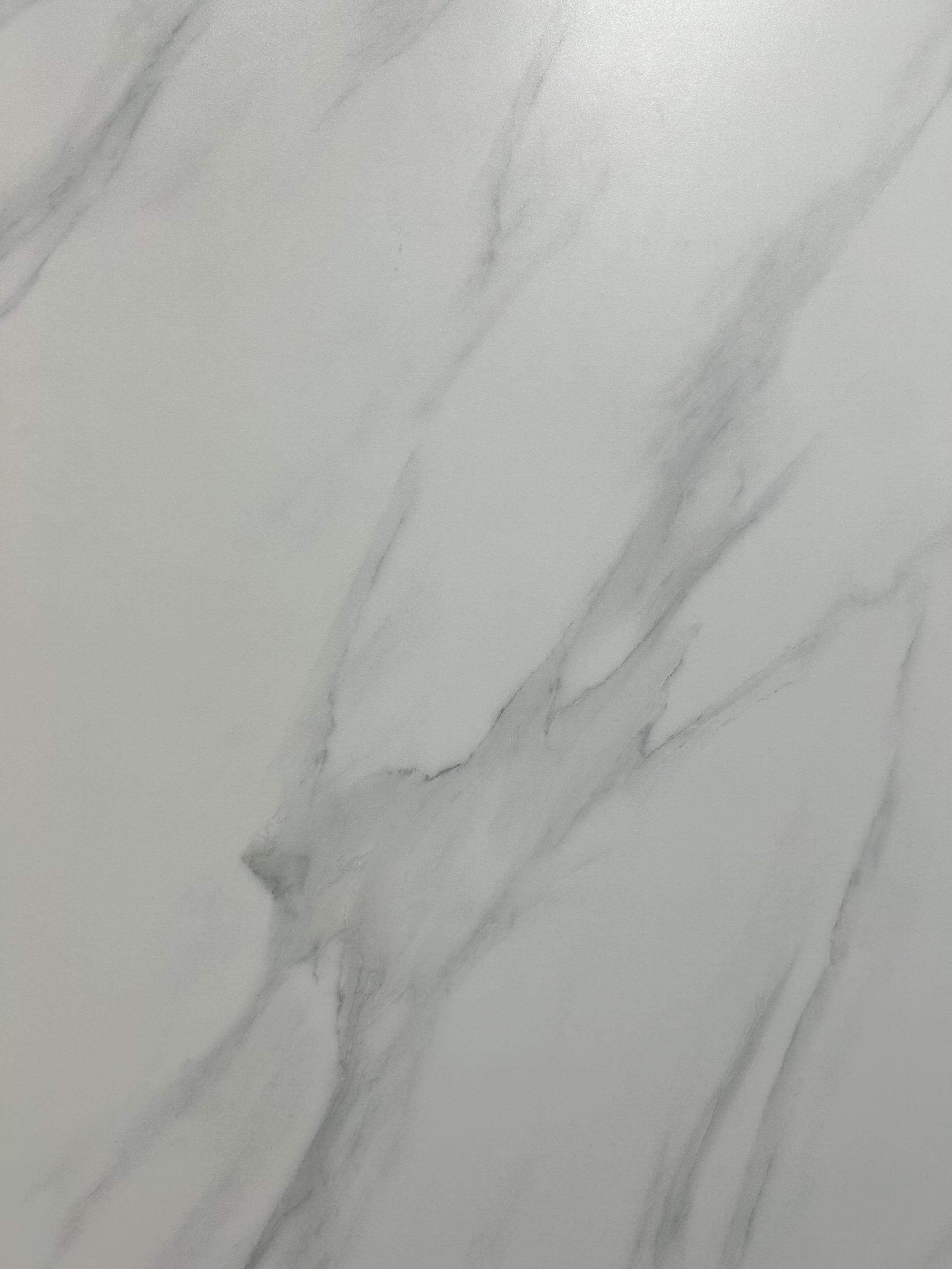 Крупный план плиты из спеченного камня Carrara White с прожилками белого камня, вид спереди