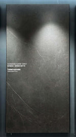 Dalle en pierre frittée gris foncé aux discrètes veines claires dans un cadre en salle d’exposition