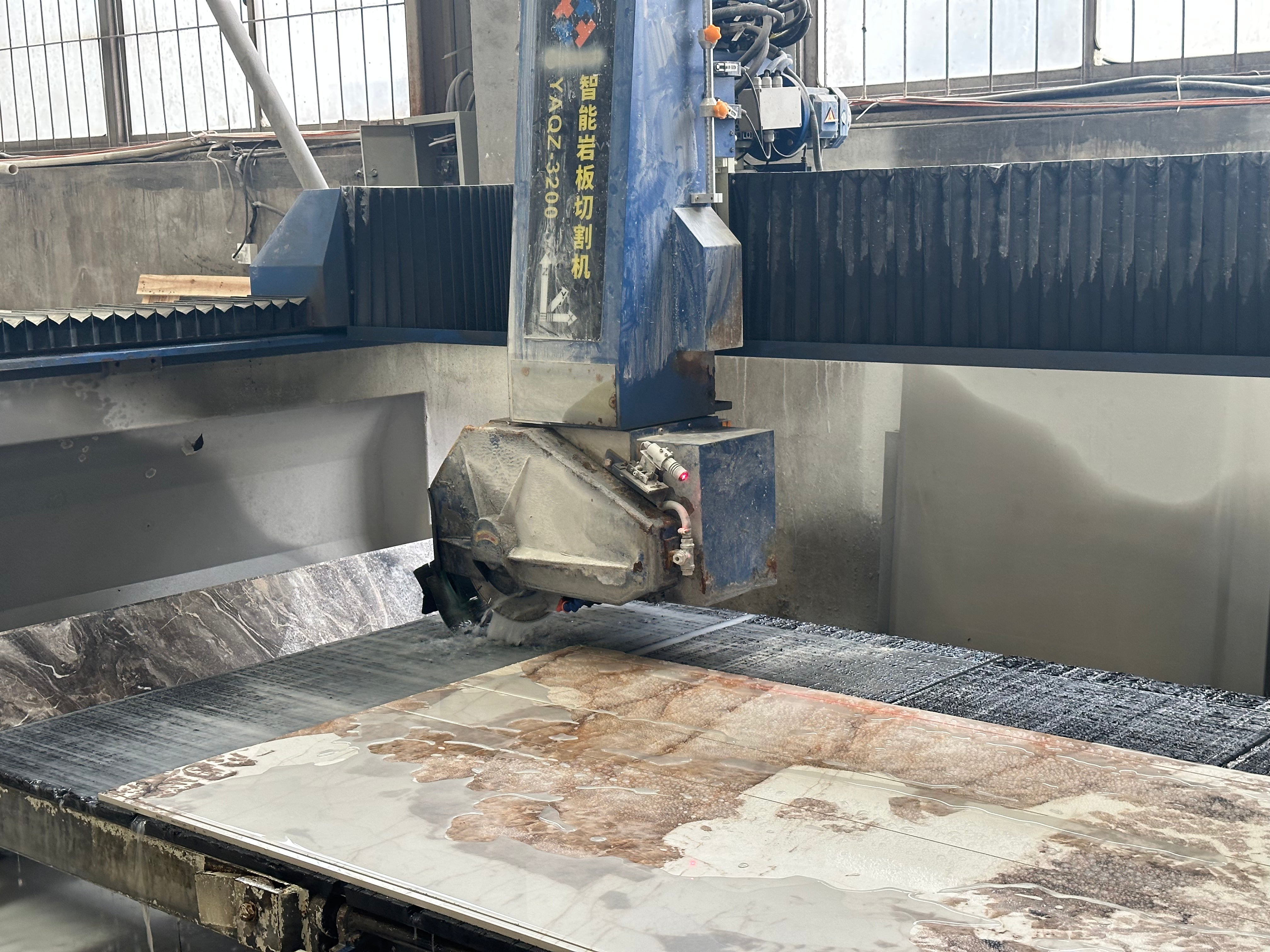 Bridge saw cutting marble-look sintered stone slab in factory