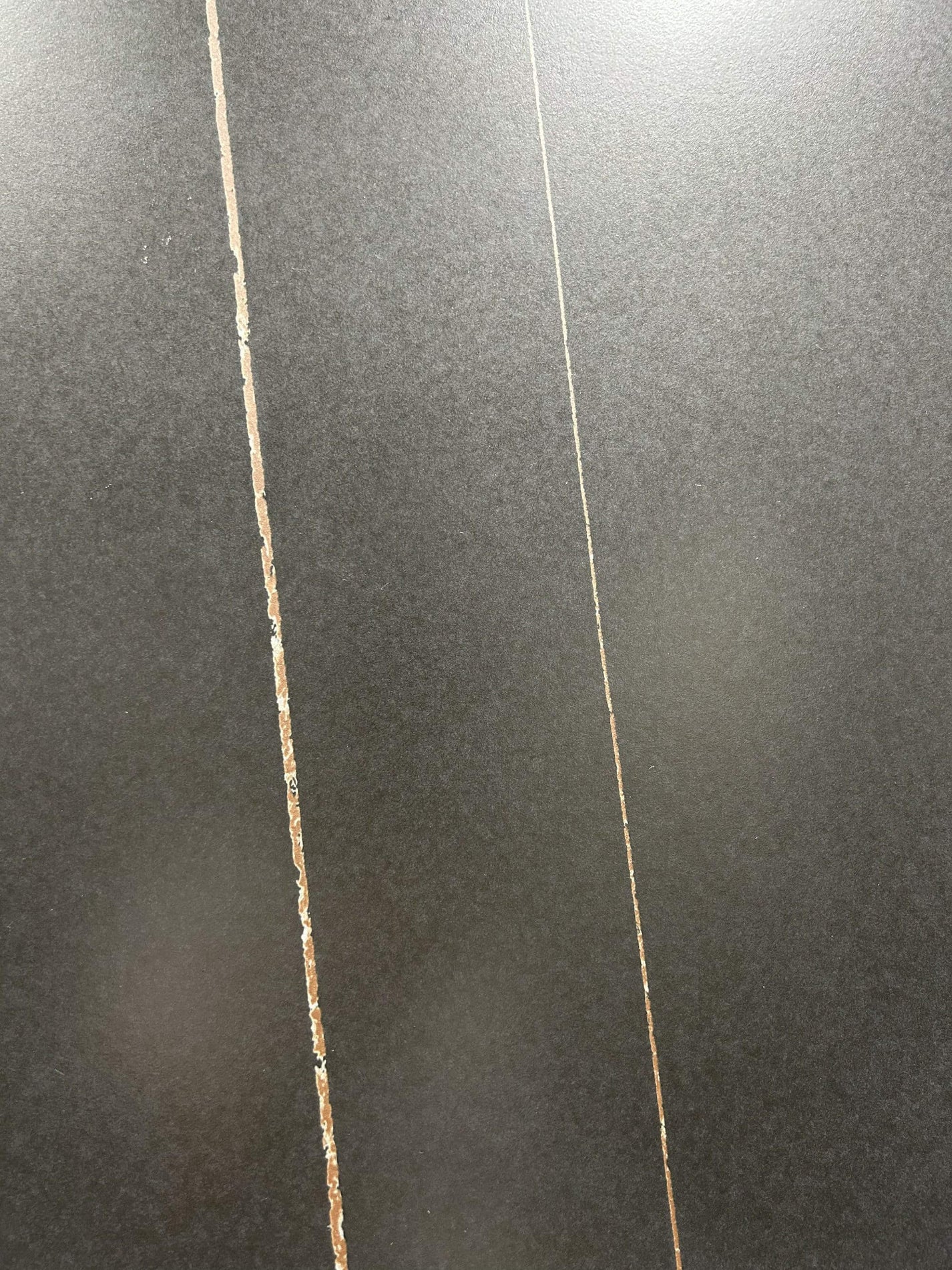 Крупный план плиты из спеченного камня Laurent Black Gold Marble Look с прожилками под мрамор.