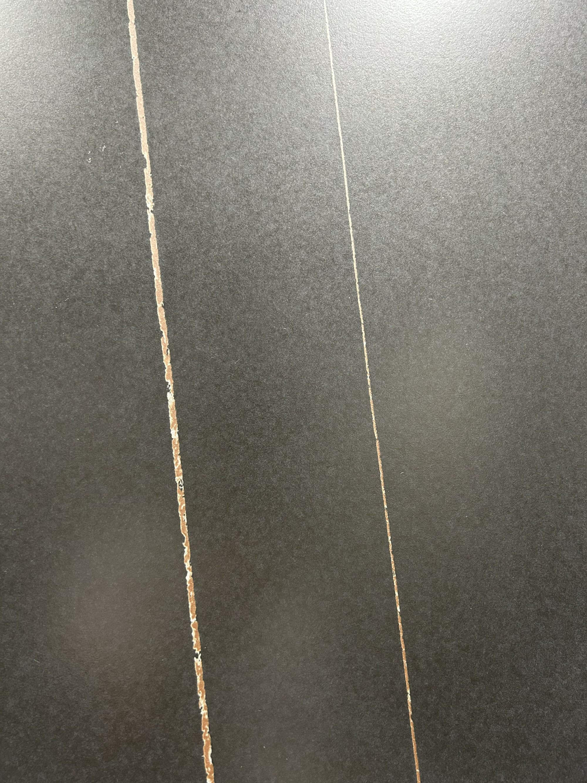 Крупный план плиты из спеченного камня Laurent Black Gold Marble Look с прожилками под мрамор.