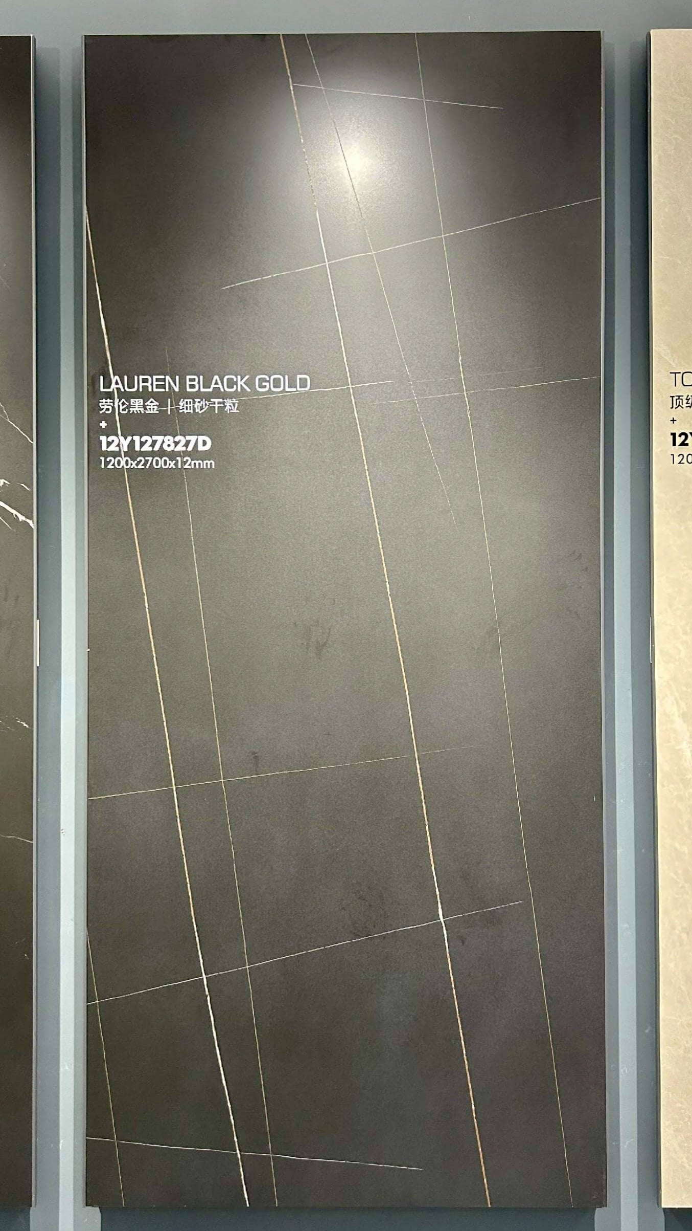 Плита из спеченного камня Laurent Black Gold с имитацией мрамора представлена ​​вертикально на витрине выставочного зала