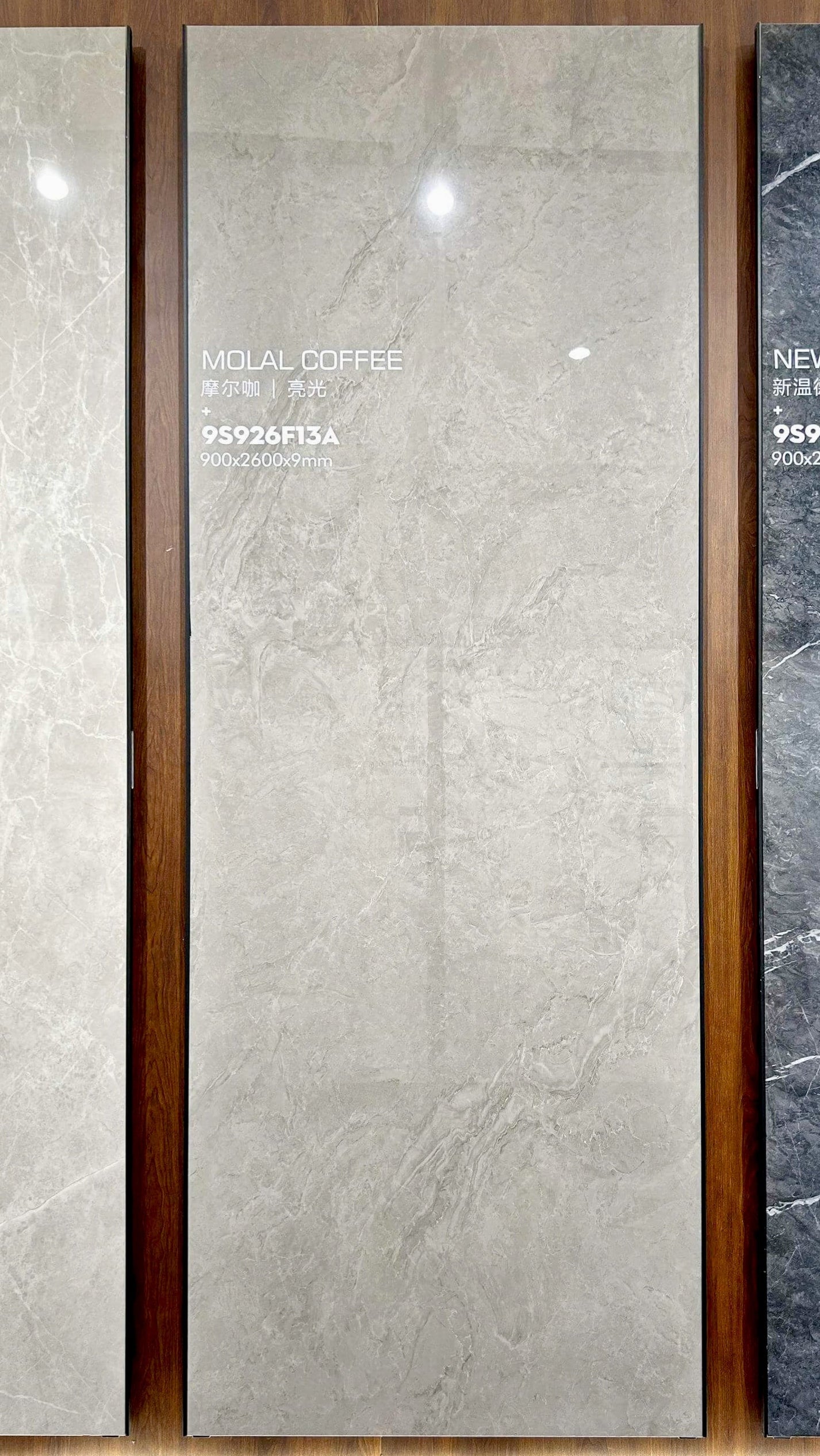 Плита из спеченного камня Moore Coffee Stone Look в вертикальном положении на витрине выставочного зала