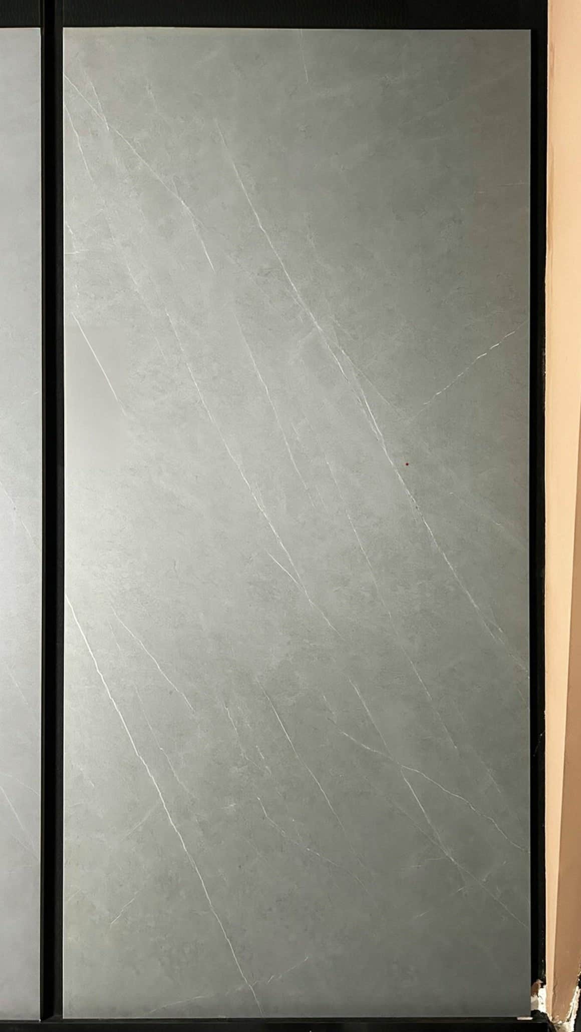 لوح حجري متكلس جديد من Armani Gray Stone Look يظهر في وضع مستقيم في صالة العرض