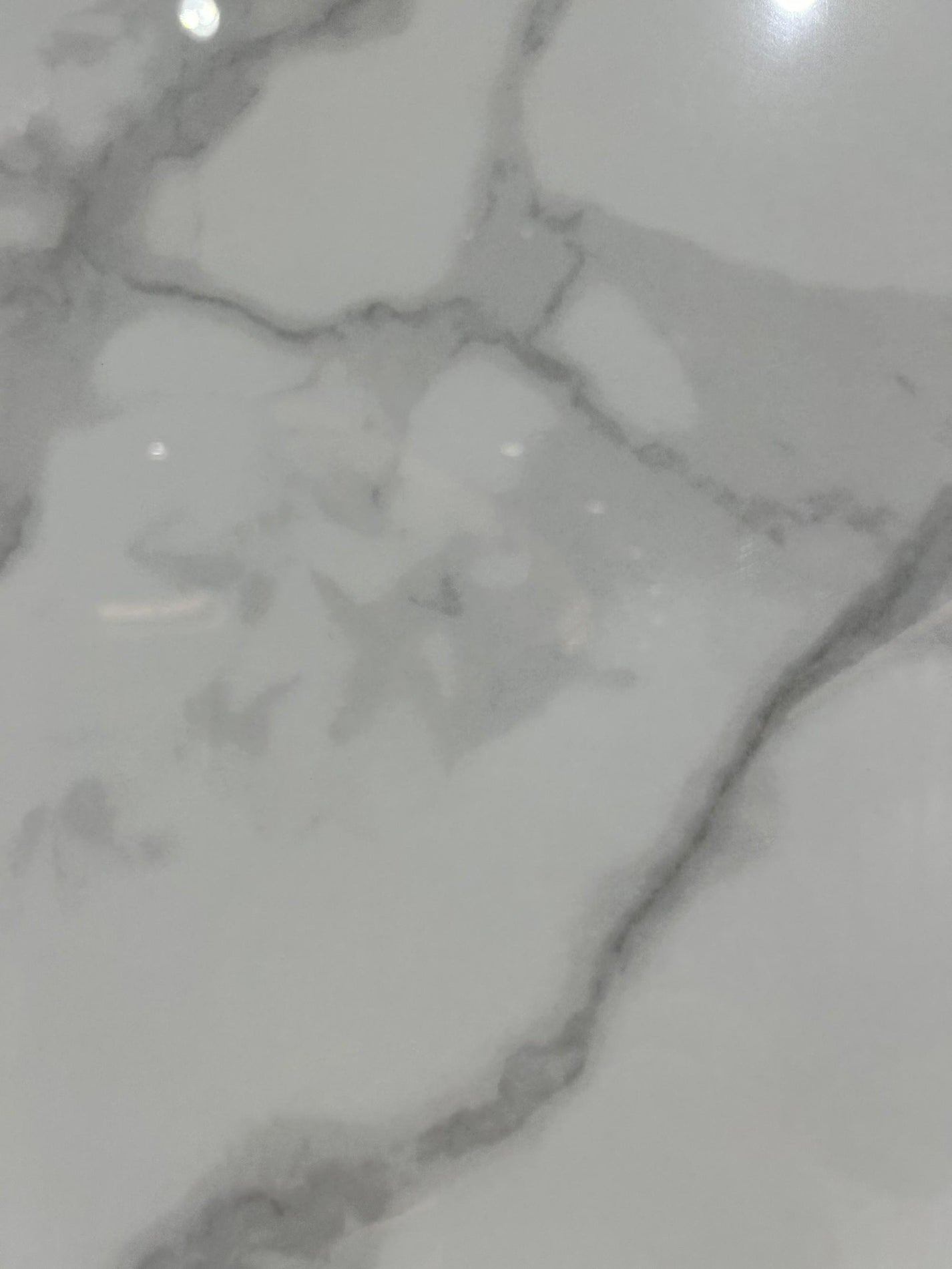 Крупный план плиты из спеченного камня Royal Fish Belly White с мягкими белыми прожилками, имитирующими мрамор, вид спереди