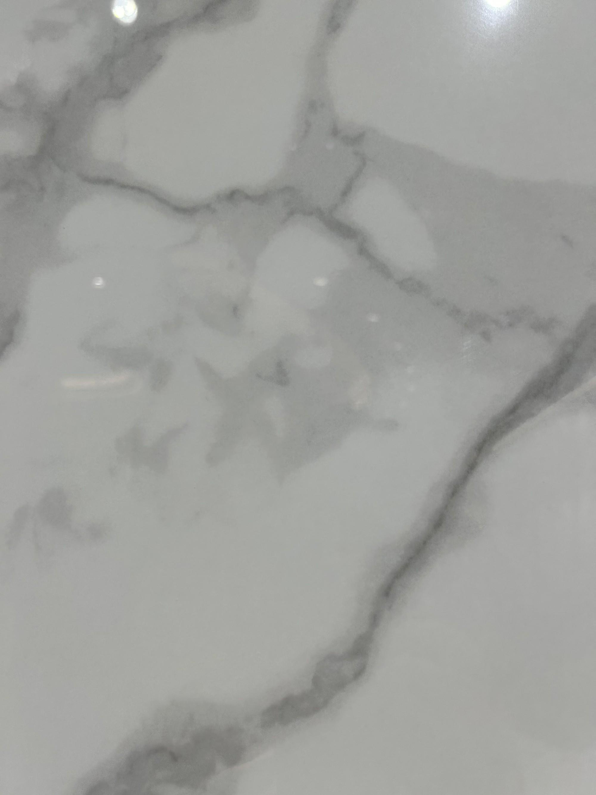 Крупный план плиты из спеченного камня Royal Fish Belly White с мягкими белыми прожилками, имитирующими мрамор, вид спереди