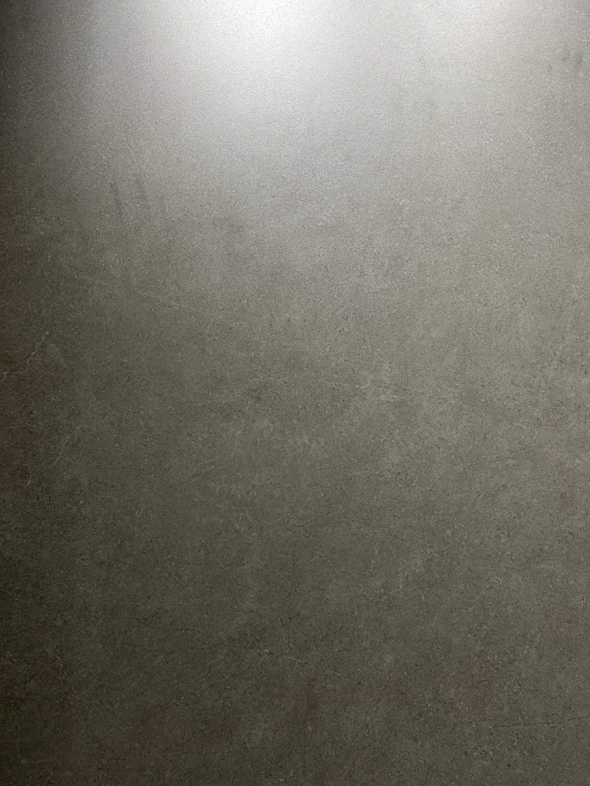 Крупный план плиты из спеченного камня Rock Grey Stone Look, показывающий движение серого камня