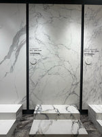 White and grey veined showroom wall slab with a matching stepped display — Alabaster White Soft Network Vein sintered stone