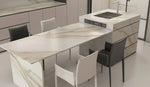 Alice Gold full-body sintered stone dining island countertop and cabinet panels in a pale kitchen