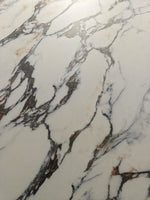 Primer plano de vetas gris oscuro ramificadas que separan grandes manchas blancas: piedra sinterizada Exquisite Bulgari White Breccia Look