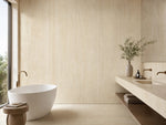 Mur de salle de bains crème à veines verticales à côté d’une baignoire îlot — pierre frittée Roman Yellow Jade Cream Onyx Look