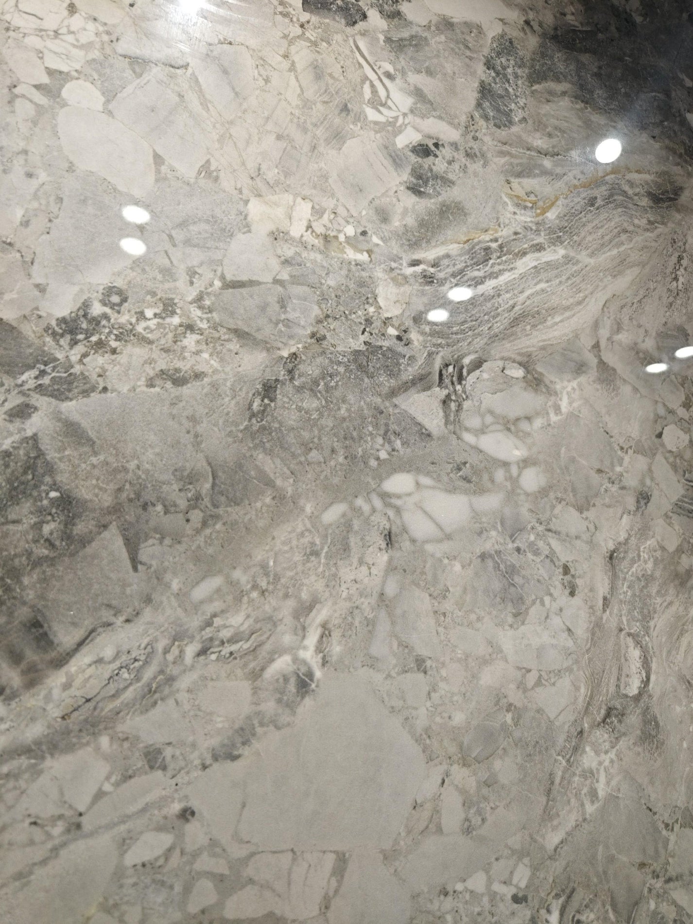 Close view of Sicilian Jade polished surface with crystalline white fragments and smoke-grey bands