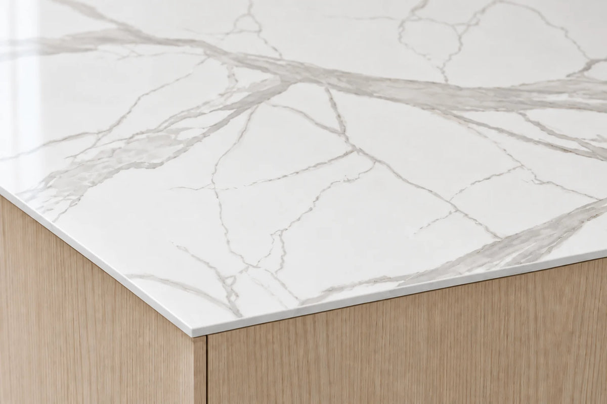 Super Snow White sintered stone countertop with a slim 12 mm exposed edge above oak cabinetry